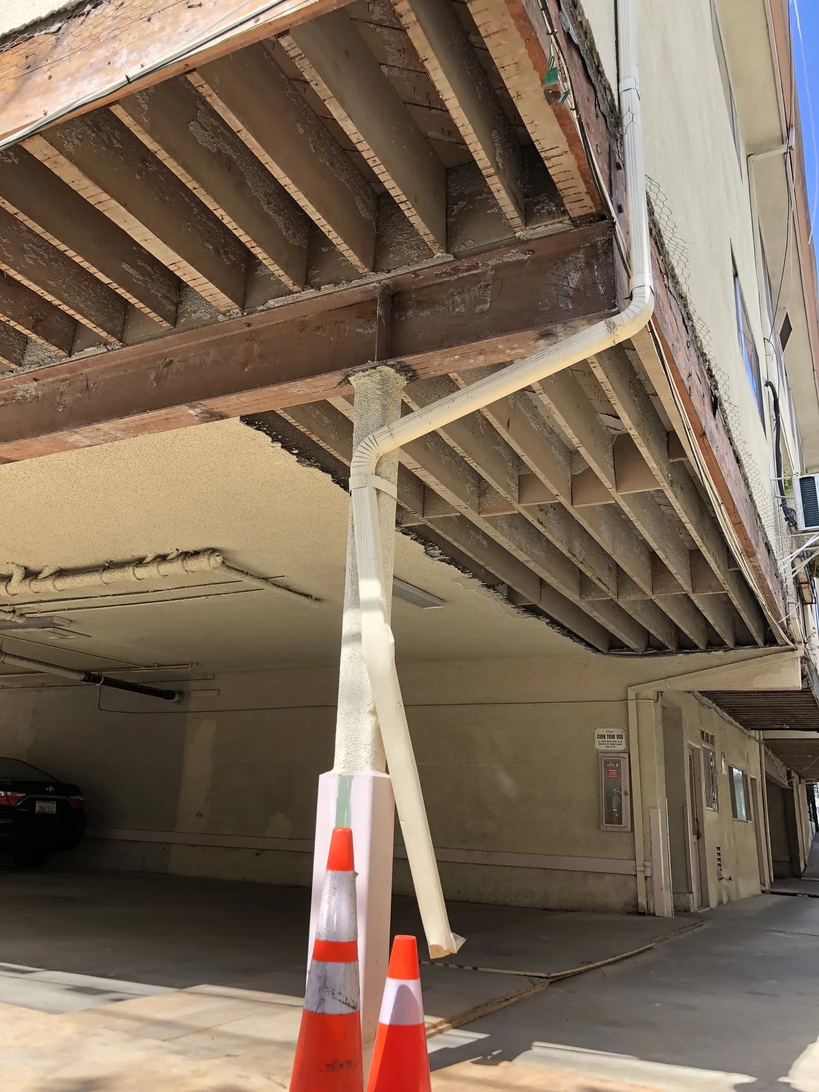 Exposed cantilever framing at the underside of an elevated walkway during balcony repair.